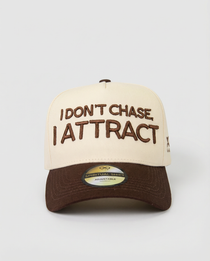 Beige and brown cap with text 'I Don't Chase, I Attract' on a white background