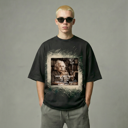Person wearing a black t-shirt with a graphic design and text, standing against a plain background