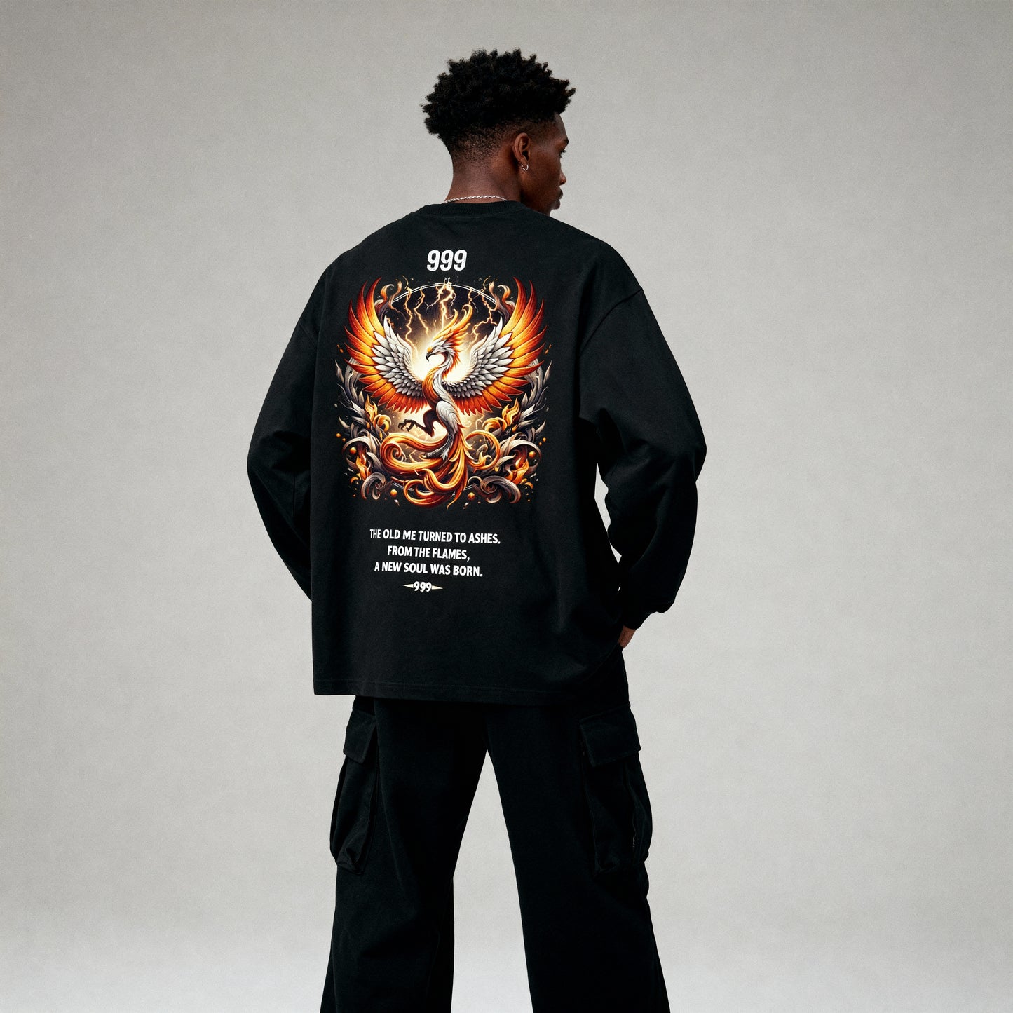 Person wearing a black sweatshirt with a colorful dragon design on the back against a gray background