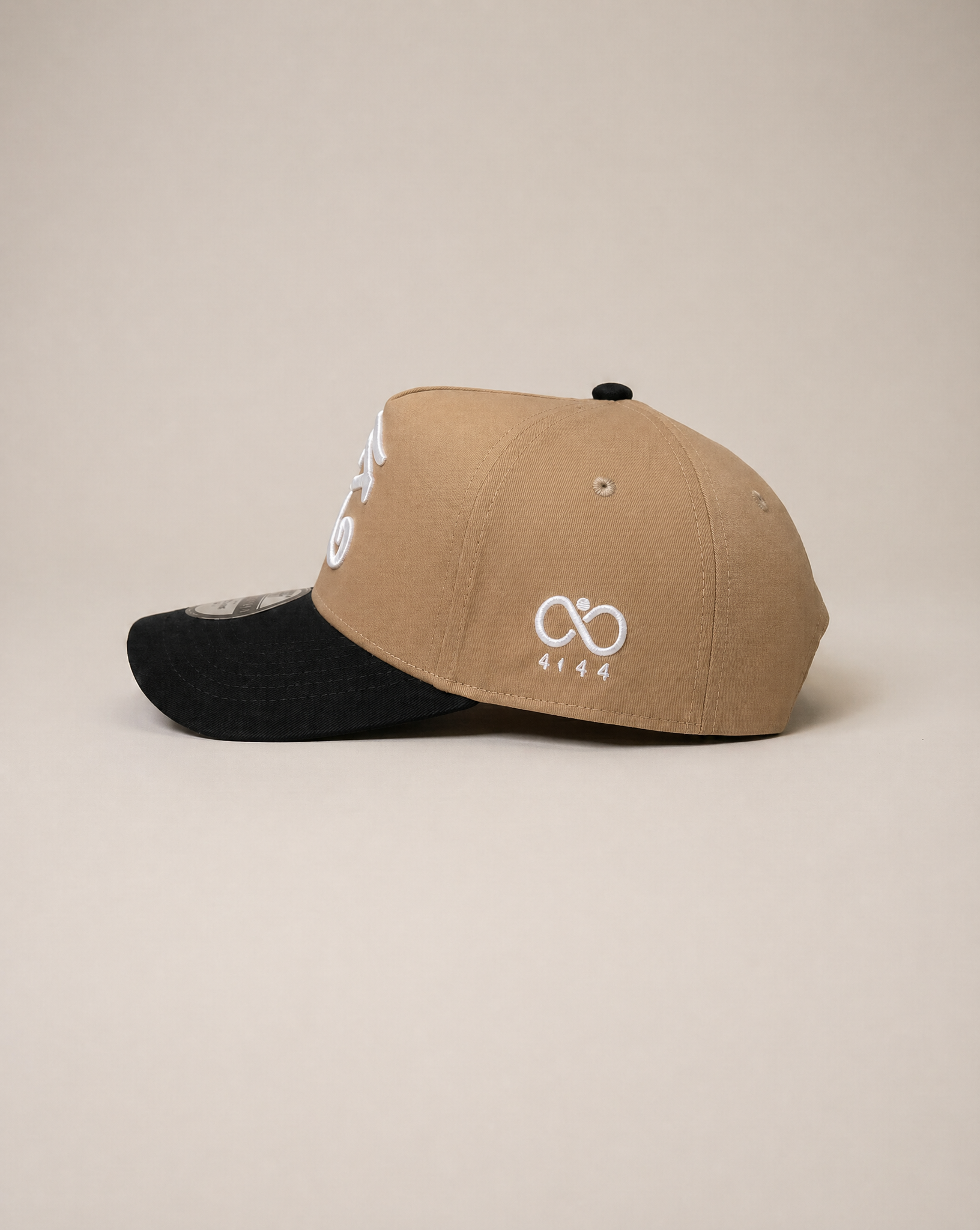 Two-tone cap with beige front and black back on a beige background